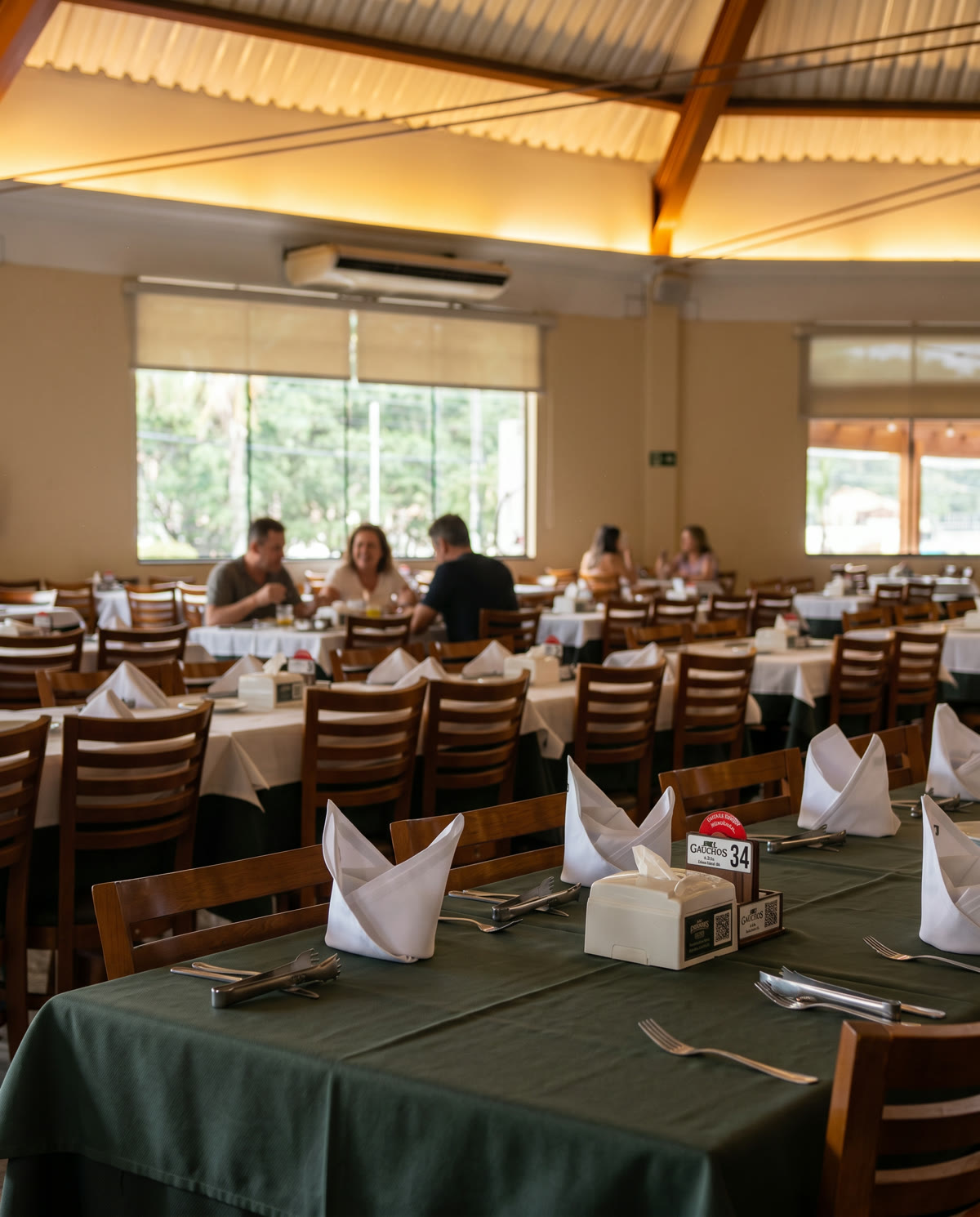 Salão da Gramado Grill preparado para receber convidados, mesas com toalhas e guardanapos dobrados